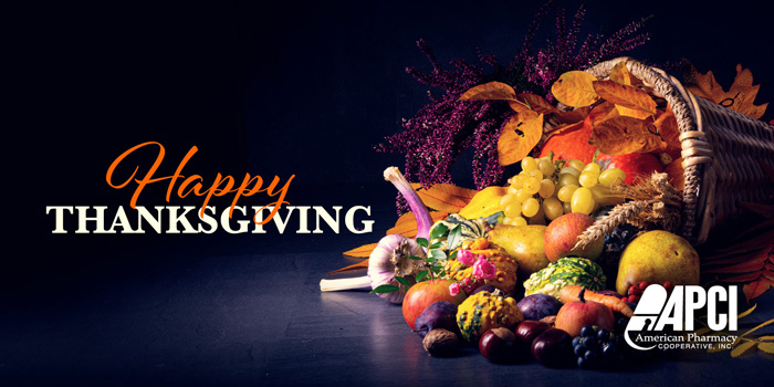 An image of a cornucopia filled with fruit and vegetables on a table with a Happy Thanksgiving message in text