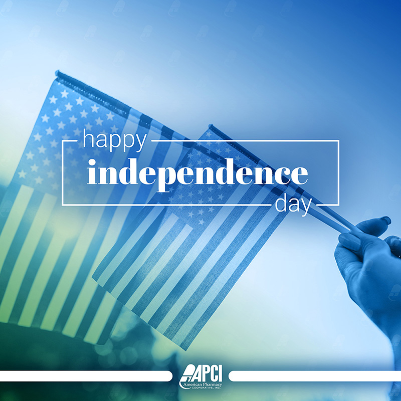 a woman's hand is holding two small American flags on a blue background